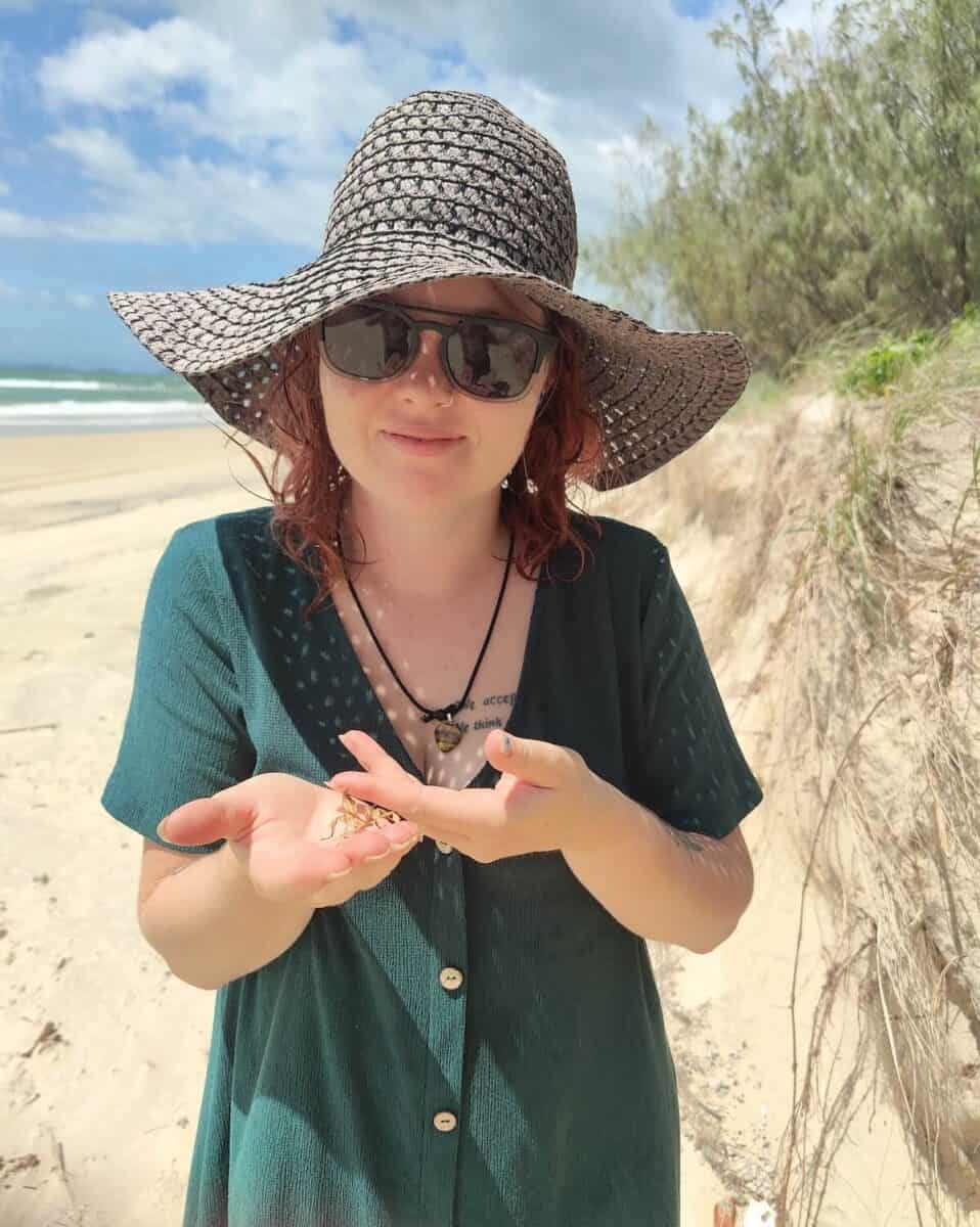 woman holding a stick insect at the beach