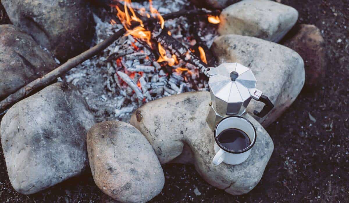 coffee percolator next to campfire