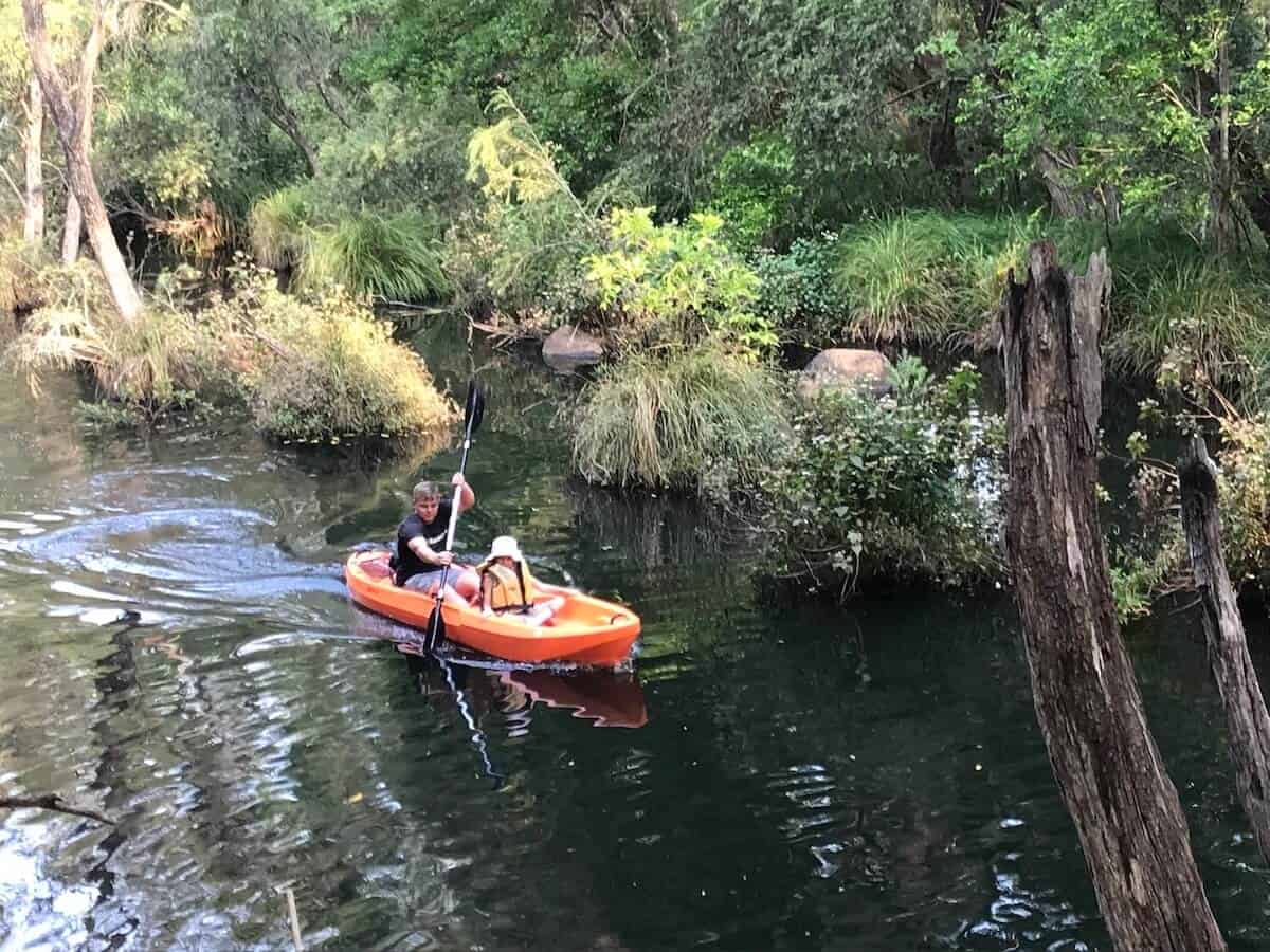 man and child in kayak on water at the gorge camping ground