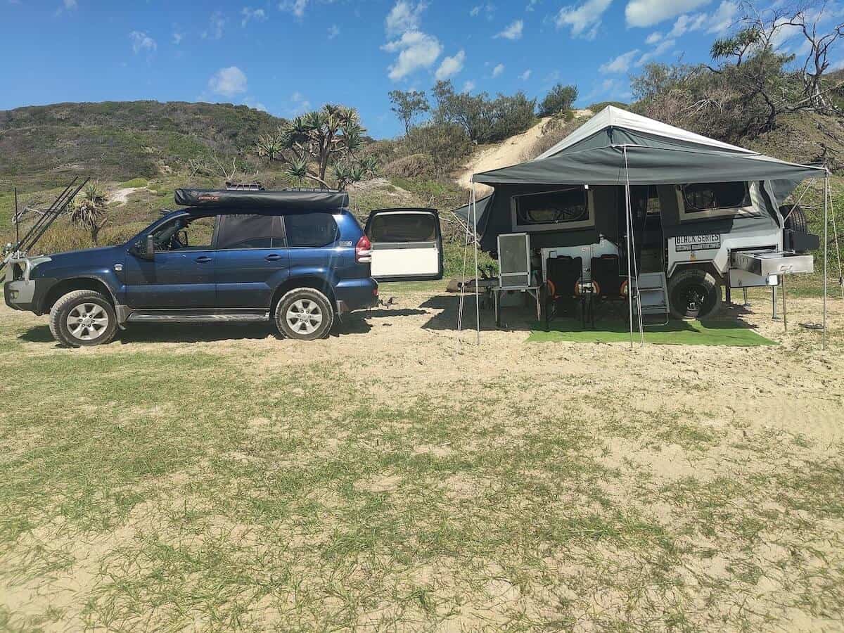 car with camper trailer set up at campsite